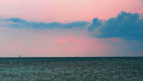 Distant-sail-boat-sailing-at-sunset-on-the