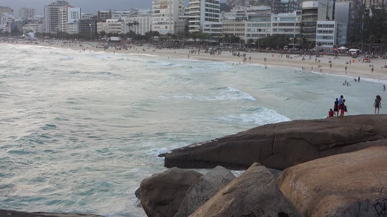 Ipanema beach at sunset, Rio de Janeiro, Brazil. seascape and city buildings, tilt up