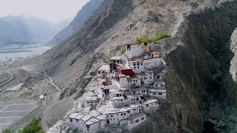 aerial view of a beautiful ancient buddhist monastery on a mountain in ladakh with valley view in background