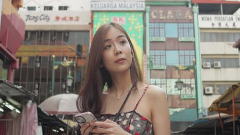 asian chinese girl looking for directions in chinatown, kuala lumpur