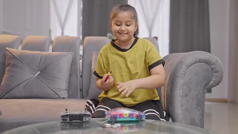 Intelligent-Indian-girl-kid-fixing-an-electrical-robot-car