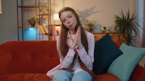 young redhead child girl praying sincerely with folded arms asking god for help, begging apology