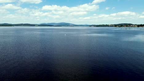 cinematic-view-from-a-drone-flying-over-the-water-surface-above-a-big-blue-lake