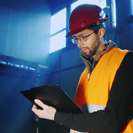 an engineer works in a warehouse and uses a tablet 15