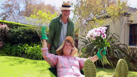 senior man giving woman ride in wheelbarrow 4k