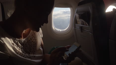 mujer en el avión cambiando la configuración del teléfono