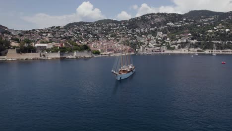 Breathtaking-Luxury-Yacht-with-Sailing-Masts-on-Cote-d'Azur,-French-Riviera-Coastline,-Aerial-Orbit