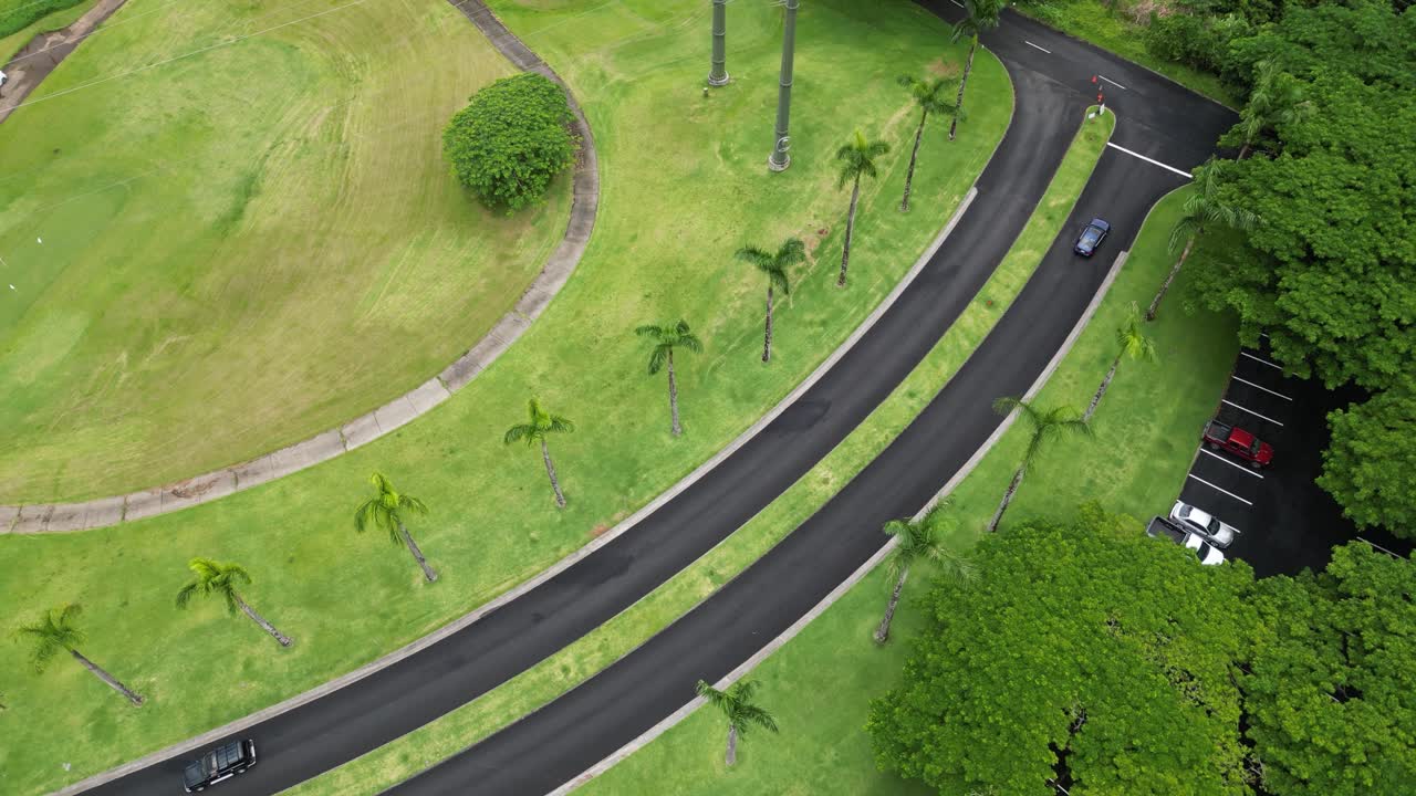 Vertical aerial view of roads, fields, power lines, palm trees and parking in Big Island, Hawaii.