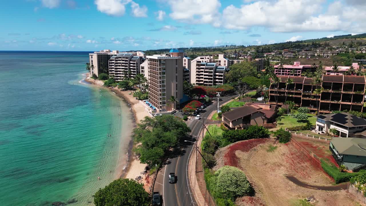 Aerial view of a vibrant tropical resort area with beach, clear ocean, and coastal buildings