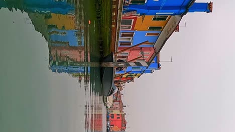 vista panorámica inusual de ángulo bajo de las casas coloridas de burano vistas desde el centro del canal, italia