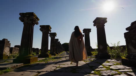 woman walking through ancient ruins