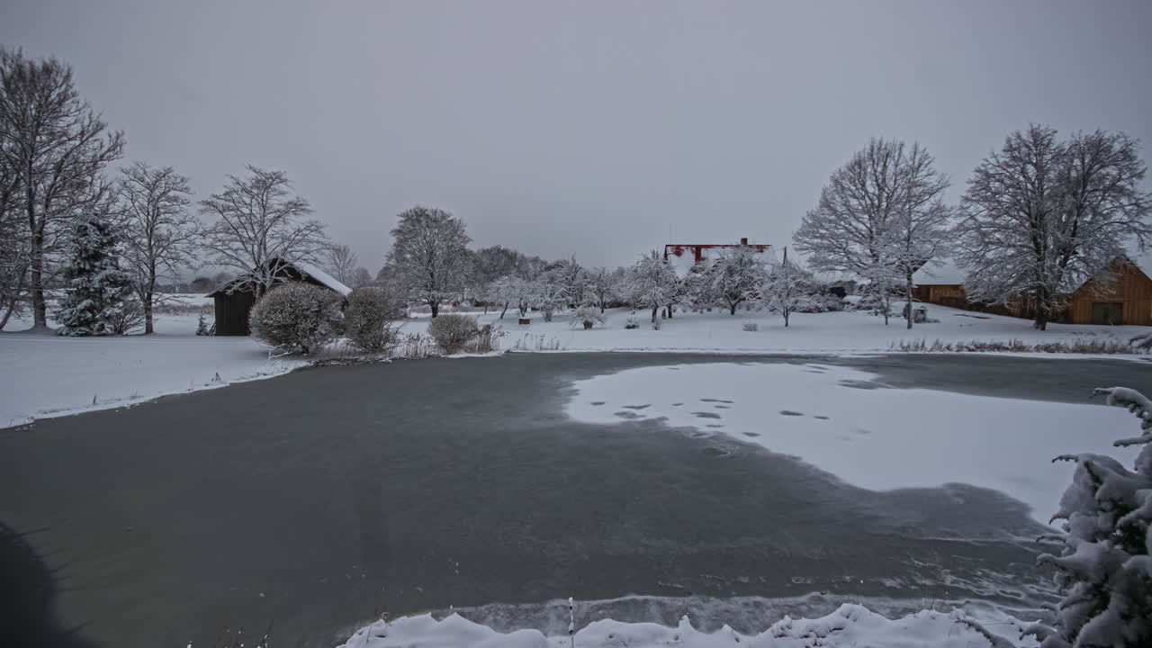 자연 속에서 낮 동안 얼어붙은 호수가 녹는 회색 겨울날의 저속 촬영 - 자연 연못과 눈이 있는 시골 풍경의 5k 시간 경과 - 아침에 어두운 일출