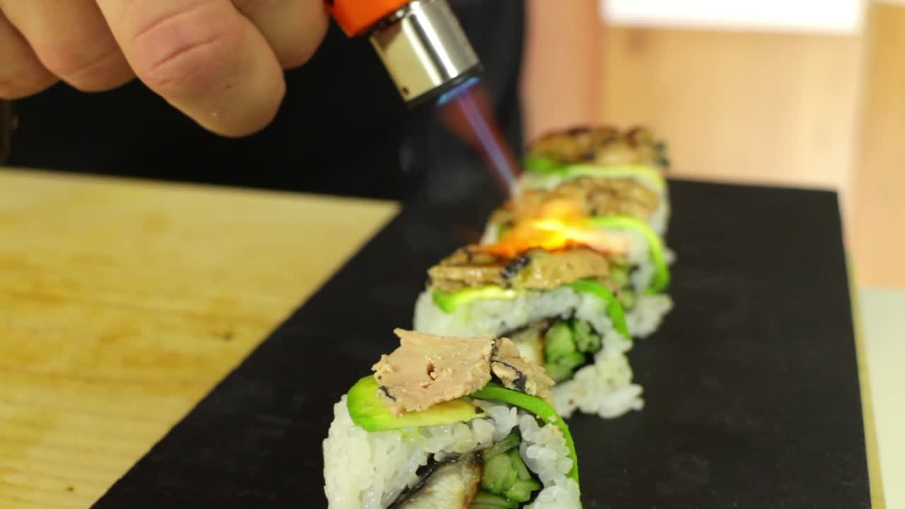 chef de sushi quema foie gras en rollo de sushi