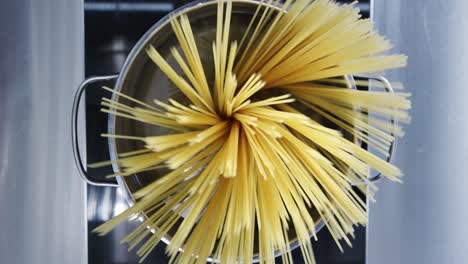 a handful of spaghetti is placed in a pot of water