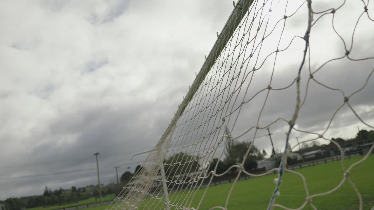 Graceful football goal in captured in closeup slow motion on cloudy day