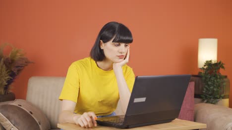 woman looking at laptop is thoughtful.