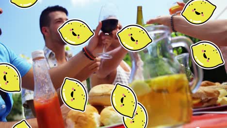 animation of lemon icons over diverse friends at table with drinks