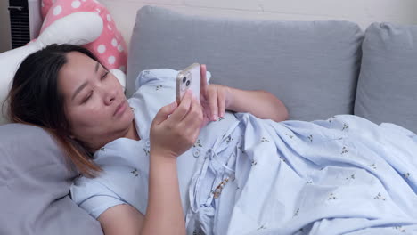 leyendo algunos mensajes y revisando sus redes sociales mientras estaba acostada en su sofá en su sala de estar