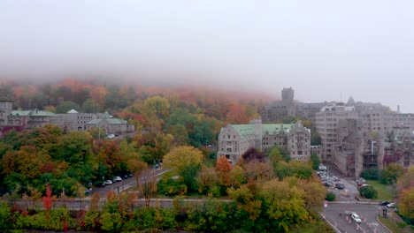 drone pulling away from baronial old building located on the mount-royal mountain on a colourful fall misty morning