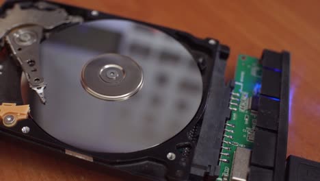 hard disk is lying on table, blinking and spinning disk. work of hacked