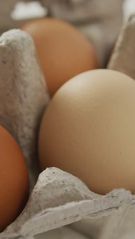video de primer plano de huevos marrones en cartón de huevos en un fondo rústico