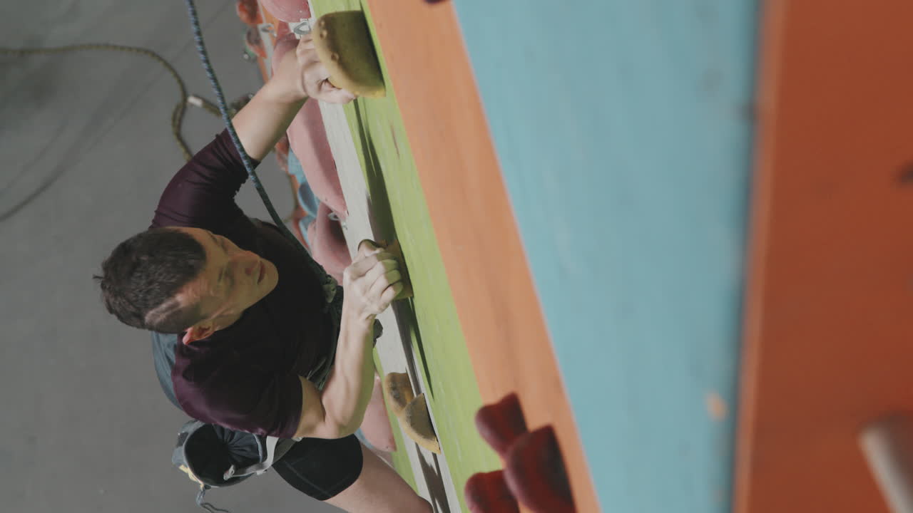 Top-View Of Male Athlete With Amputated Leg Climbing Indoor Wall