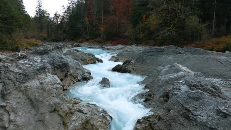 Mountain-river-waterfall-canyon-with-fresh-blue-water-in-Bavaria-Austria-alps,-flowing-along-a-forest-and-trees-near-Sylvenstein-Speicher-and-Walchensee