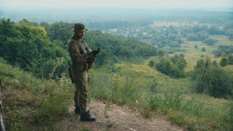 a man in camouflage looks at a compass 1