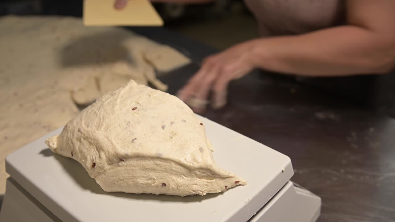Close-up of weighing dough before baking bread. Craft bakery. Fast Professional Work of Bakers