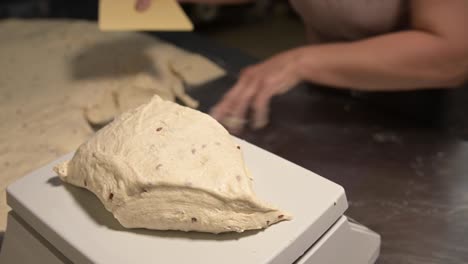 close-up of weighing dough before baking bread. craft bakery. fast professional work of bakers