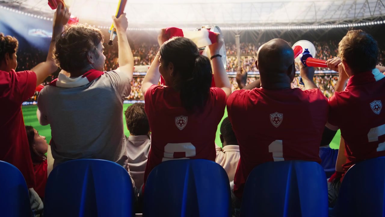 ブブゼラを鳴らして歌う応援ファンの中でドラムを叩くサッカーサポーター