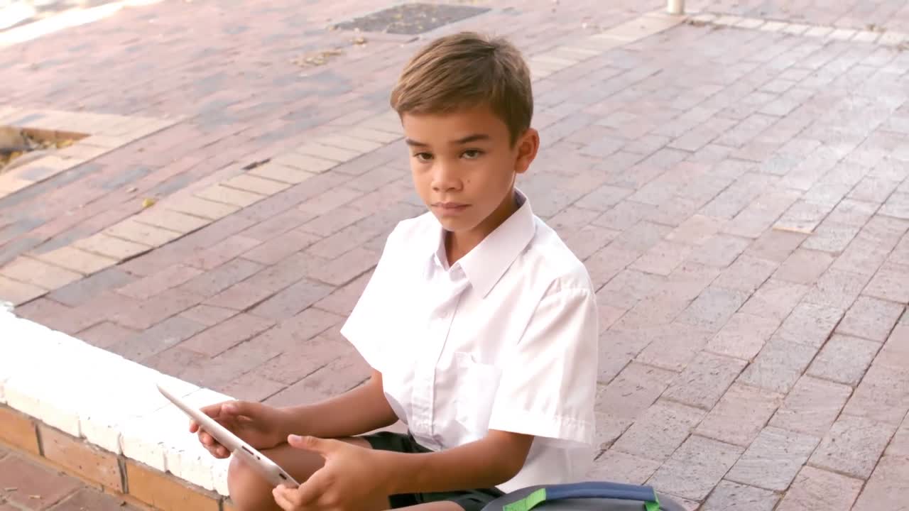 디지털 태블릿을 사용하는 귀여운 학교 소년의 초상화
