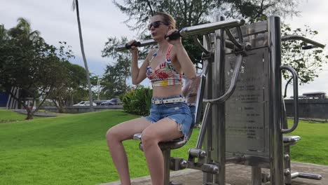 woman exercising outdoors on outdoor gym equipment