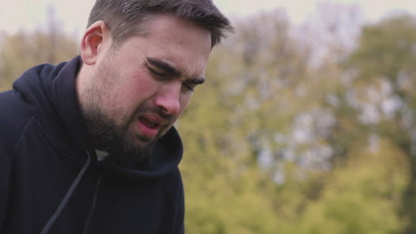 tired man having shortness of breath at park in the morning