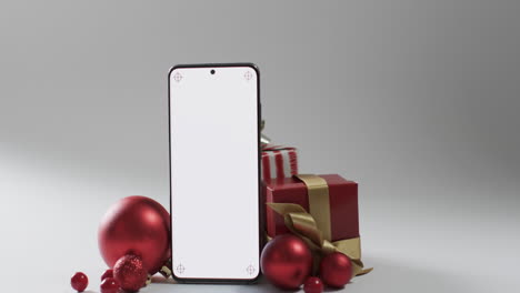 Vídeo-De-Regalos-De-Navidad,-Adornos-Y-Smartphone-Con-Espacio-Para-Copiar-Sobre-Fondo-Blanco.