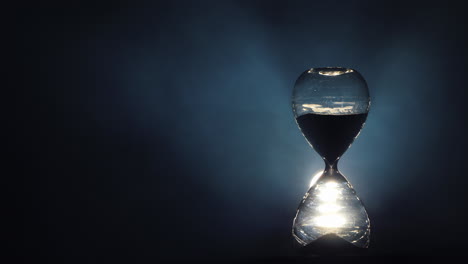 hourglass on a black background with mist swirling 3