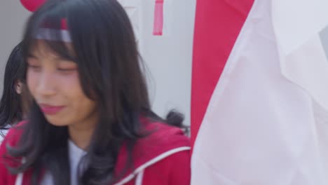 young man and woman holding and kiss the indonesian flag on indonesia independence day ceremony