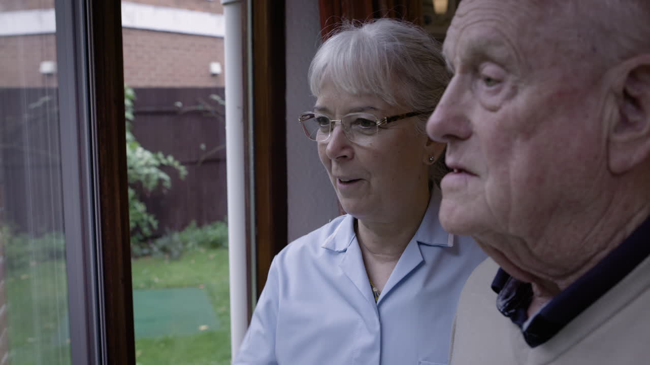 Elderly man and nurse by the window