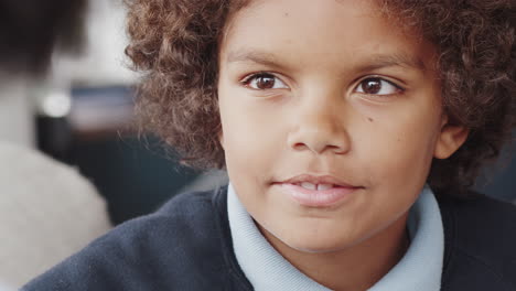 Head-shot-of-pre-teen-boy-looking-up-at-his-parent-and-talking,-selective-focus