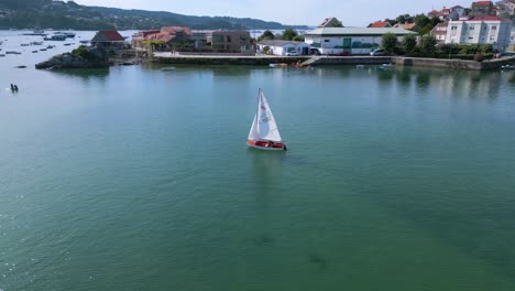 Aerial-View-Of-Sailboat-Cruising-In-The-Blue-Sea-In-Summer-In-Aldan,-Spain