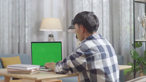 persona que trabaja en una computadora portátil con pantalla verde