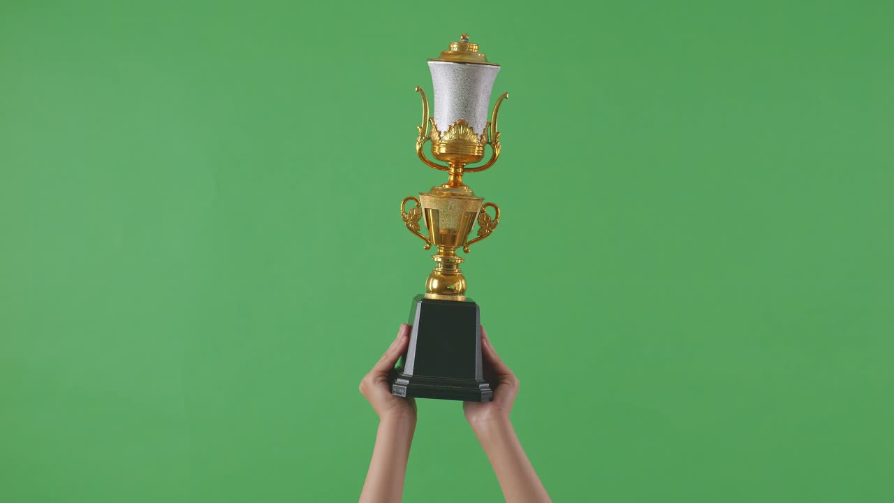 manos con un trofeo de oro