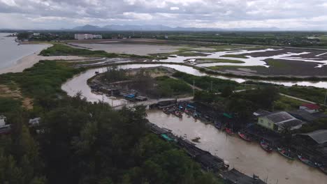 4k aerial drone footage with orbital rotation over a small fishing village along the coast of thailand