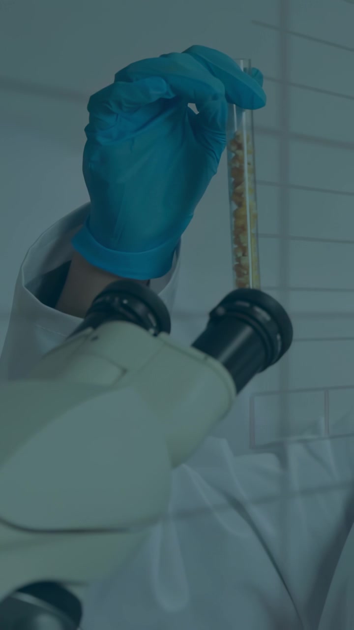 Video verticale: Scienziato di laboratorio che tiene una provetta davanti a uno strumento di analisi, ruotando e testando un campione con una sovrapposizione di curve.