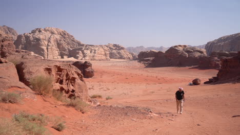 lonely man walking on sand in desert on hot sunny day