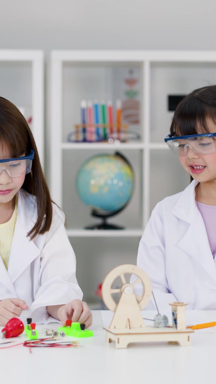 Kaksi nuorta tyttöä suojalaseissa tekee STEM-elektroniikkakoetta valoisassa luokkahuoneessa.
