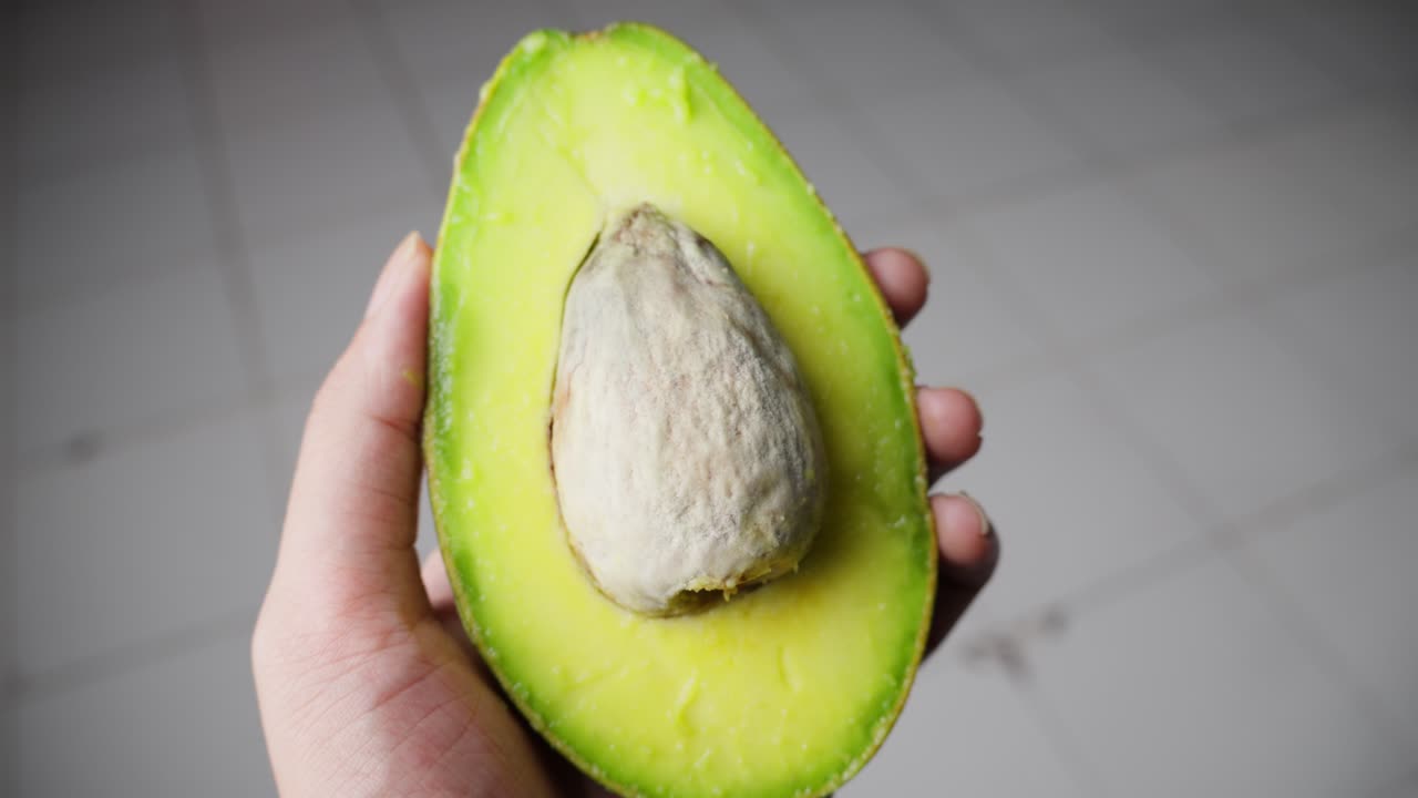 Avocado fresco tagliato a metà in primo piano.