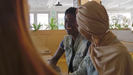 young adult female friends hanging out in a cafe