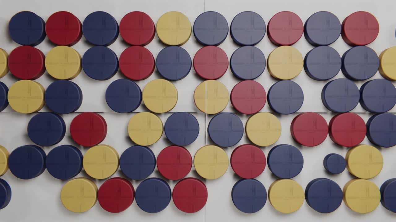 Shifting colored disks starting at center seam on white-paneled wall, small disk dropping