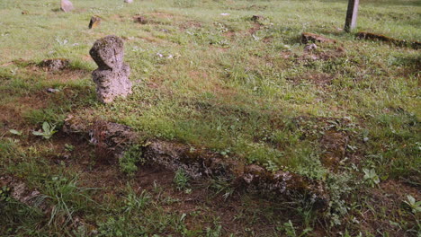 a panning view of a tombstone with an old christian grave in the graveyard